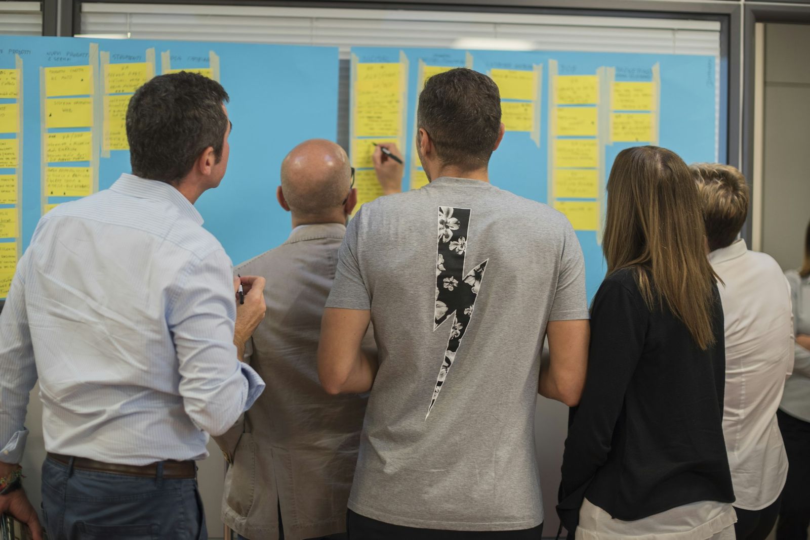 Atelier de travail : un groupe devant un mur couvert de notes.