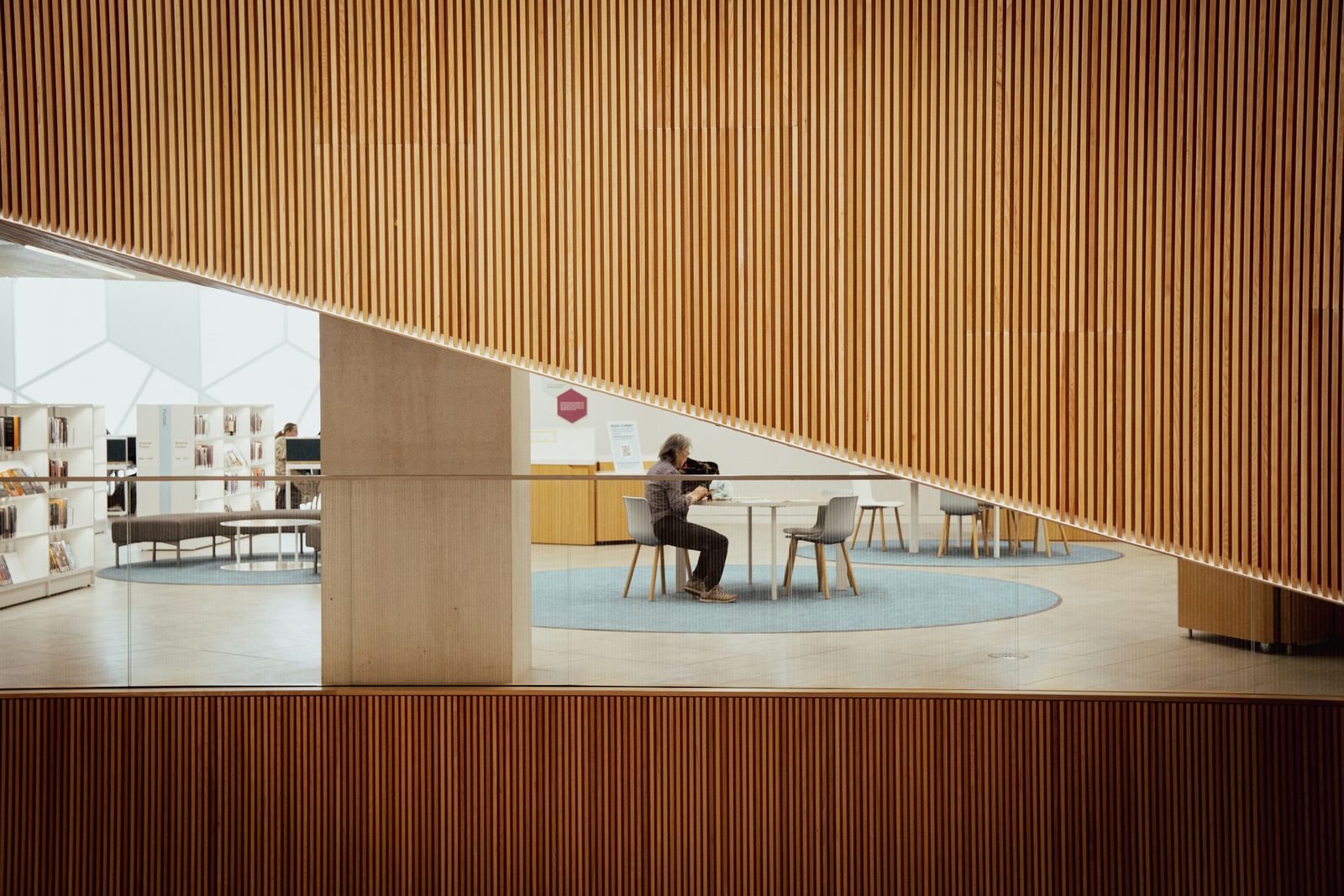 Espace de travail calme : une personne assise devant un grand mur en lames de bois.